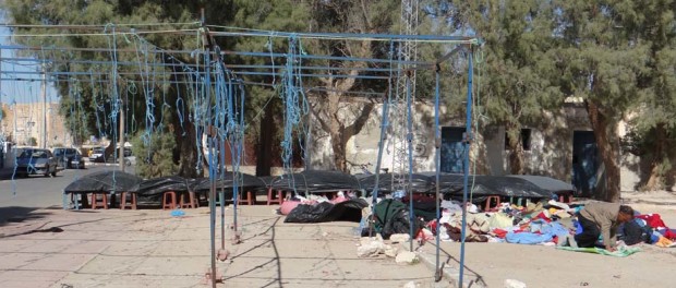 Libyan man (possibly) temporarily halts packing up in order to pray.