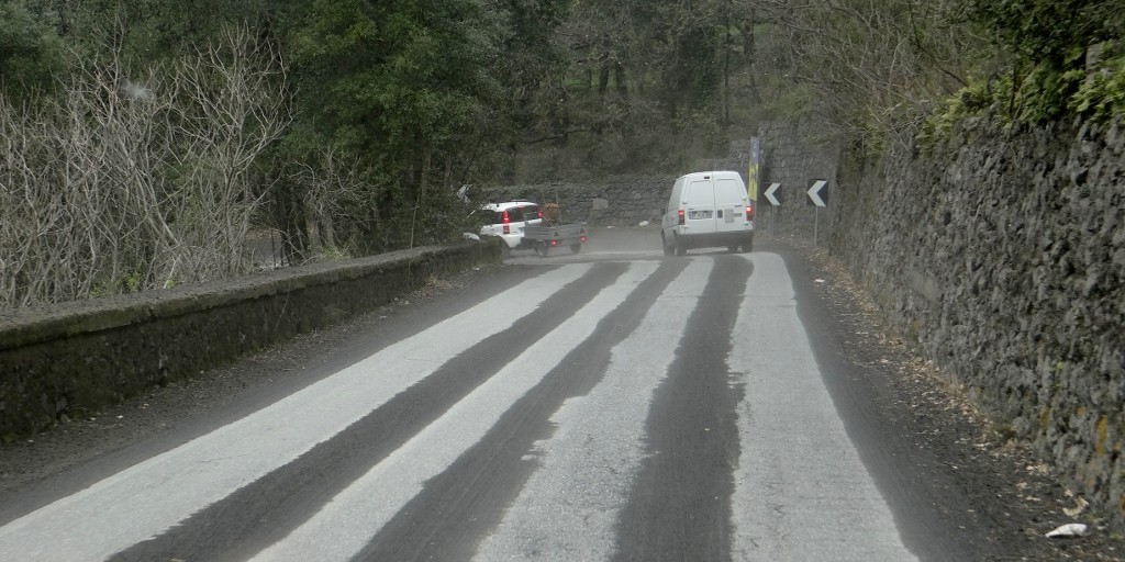 Like a negative image of snow on the UK roads, here the road is light and the lava ash black!
