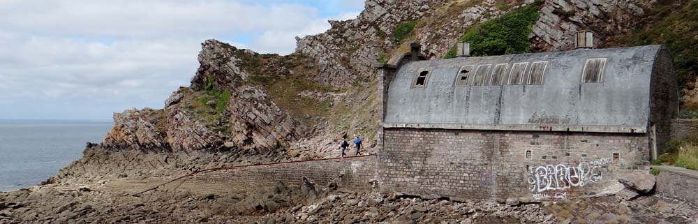 The men on their way to the sea through the abandoned lifeboat house (which still contains the launch mechanism)