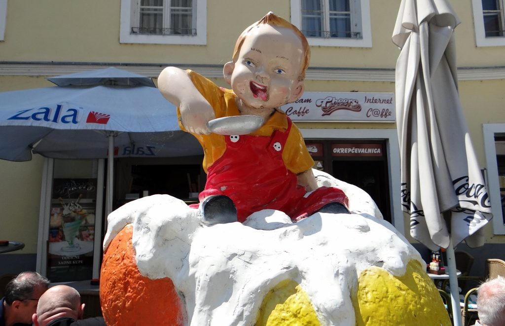 Small boy sat in huge plastic ice cream. Ju was jealous