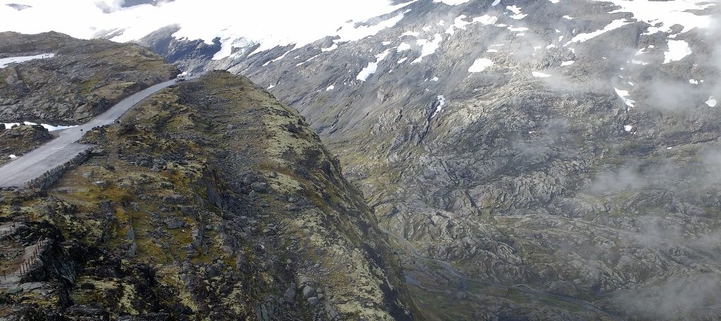 The edge of Mount Dalsnibba. The motorhome towing a boat on the road gives and idea of scale