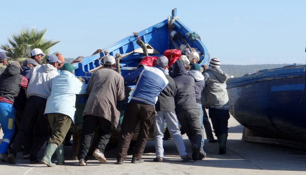 Fishermen madhandling a boat in the Essaouira port