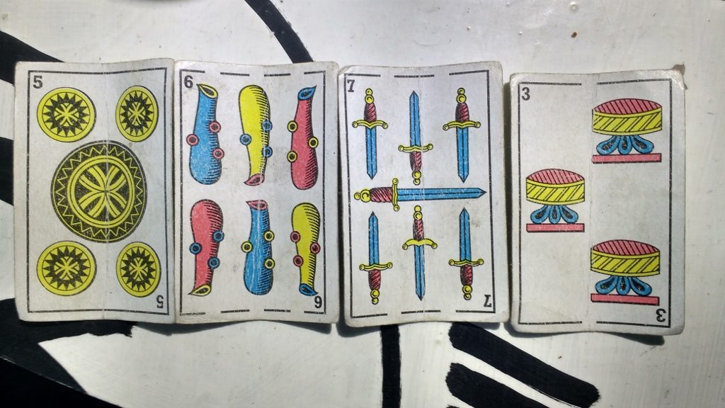 Men sat on the floor around the car park and played cards