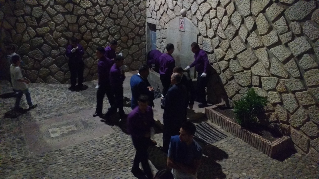 The agrupaciones ignoring the 'non-potable' sign and having a well-earned drink