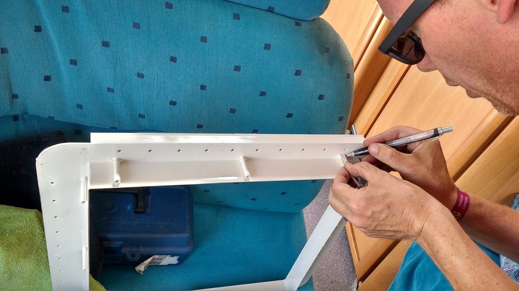 Marking the plastic pillars ready for shortening with a hacksaw