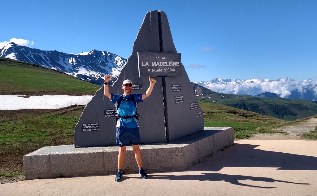 A runner by the col sign on on the Col de la Madeleine at 1993m