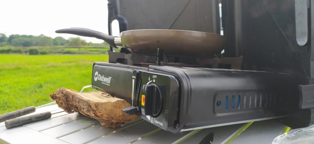 Cooking on a 'wonk' using a piece of wood to level off the gas hob (don't try this at home folks)!