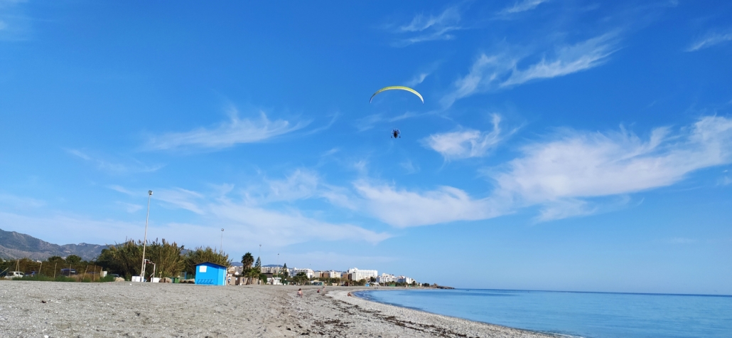 A powered paraglider breaking the silence above Playa Playazo