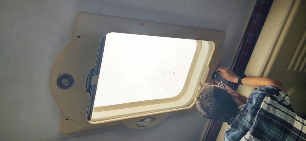 Man removing skylight panel motorhome.
