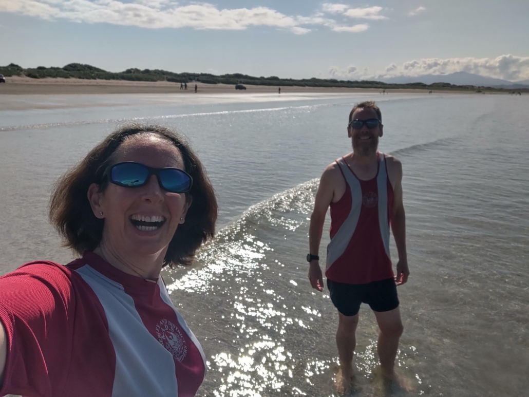 Julie and Jay in running gear paddling in the sea