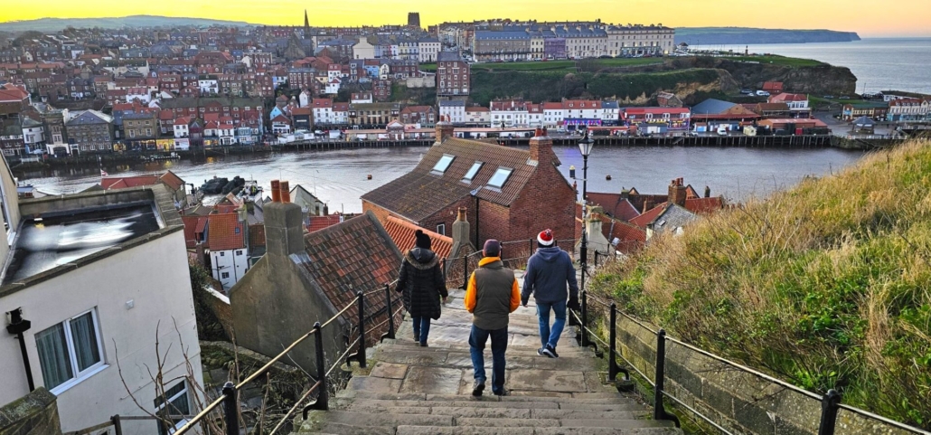 Group walking down the 199 steps looking over Whitby harbour