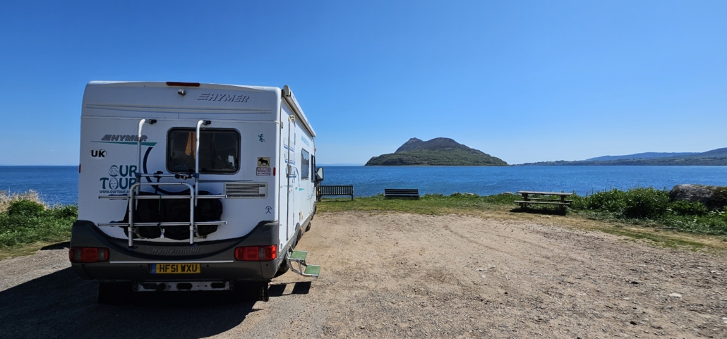 Motorhome in gravel car park overlooking the sea and an island