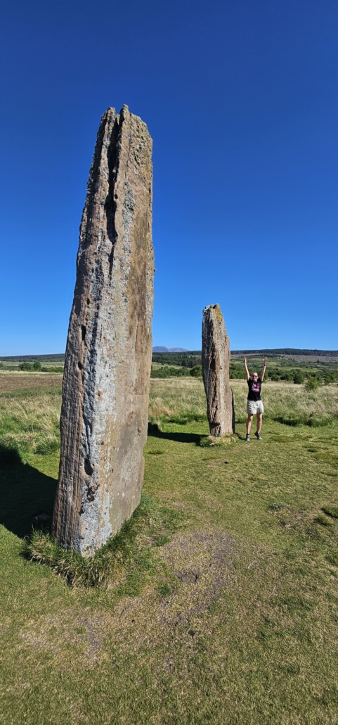 Person next to large standing stone