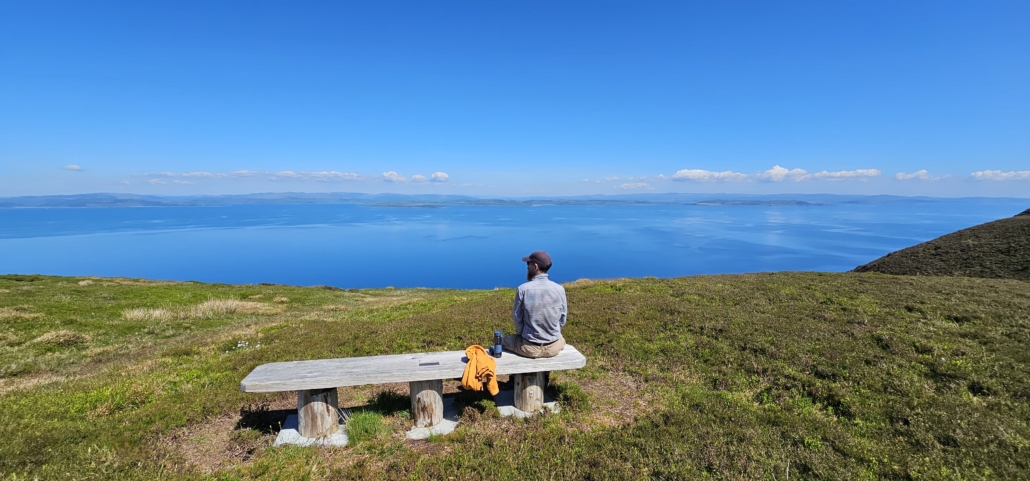 Jay sat on bench looking out to sea