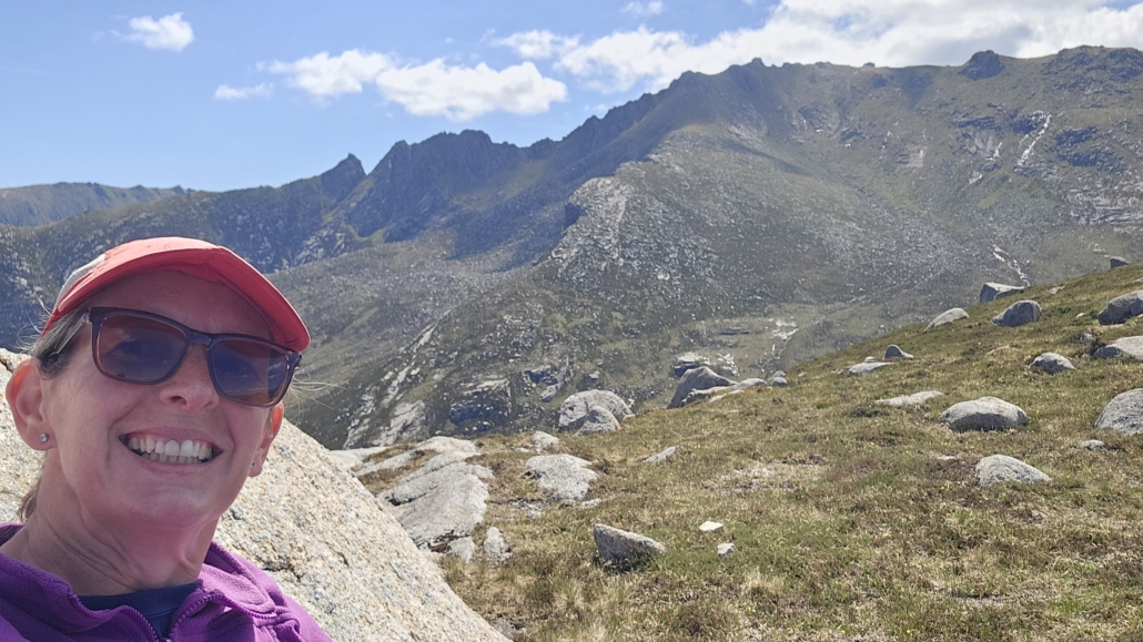 Ju enjoying sitting in the sun with the hills Jay is walking behind her