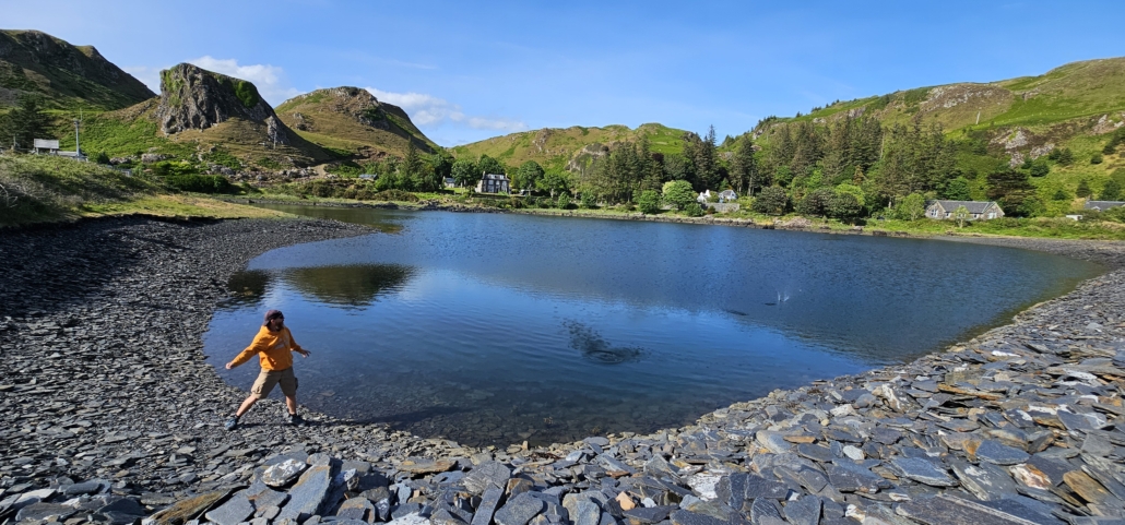 Stone skimming in a flooded slate quarry at Ellenabeich, Easdale