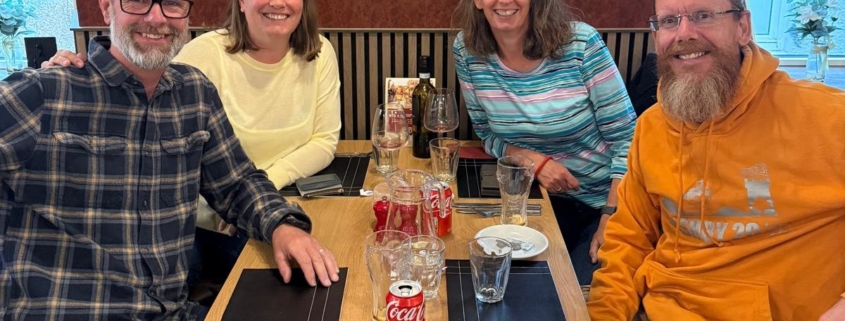 Four people sitting around a table in a restaurant