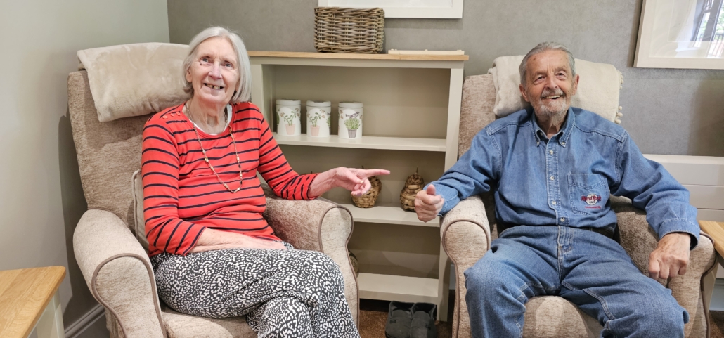 Ju's Mum and Dad sitting in chairs smiling