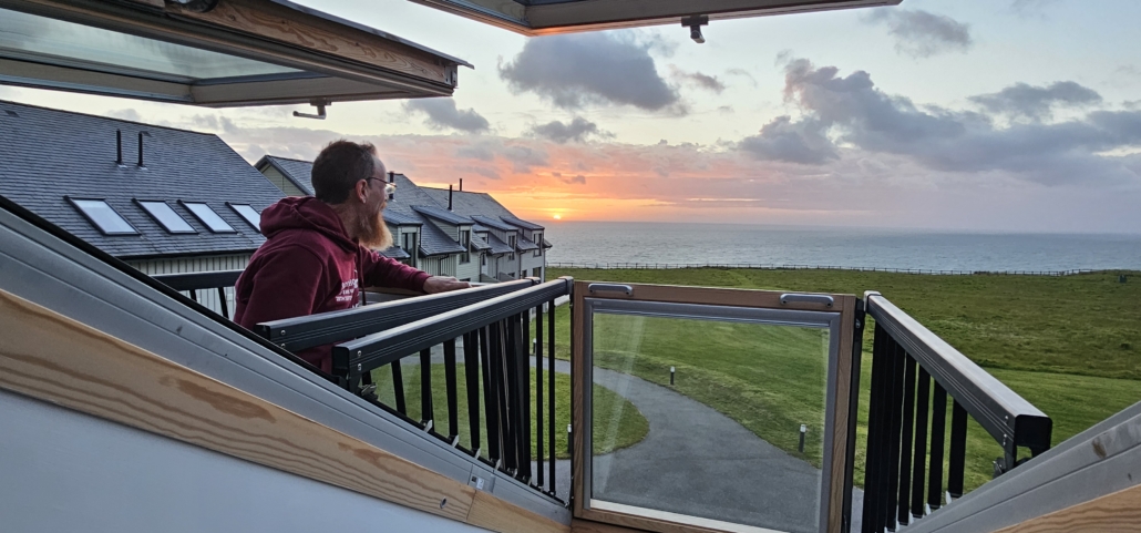 Jason looking out towards the sunset from a balcony