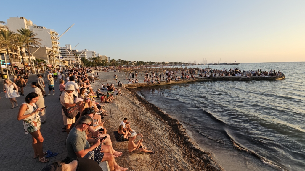 Crowds stood along a beach and sea wall waiting for the solar eclipse