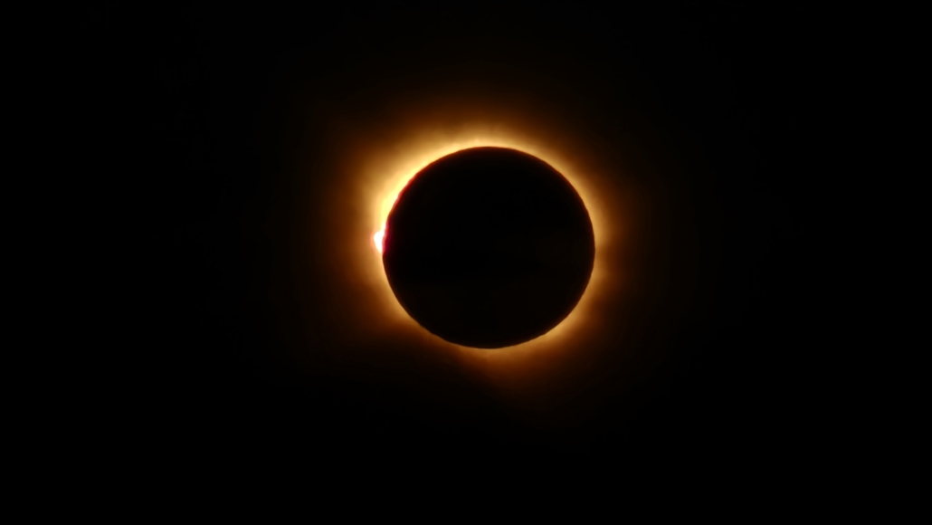 Image of the suns corona peeking out from behind the moon