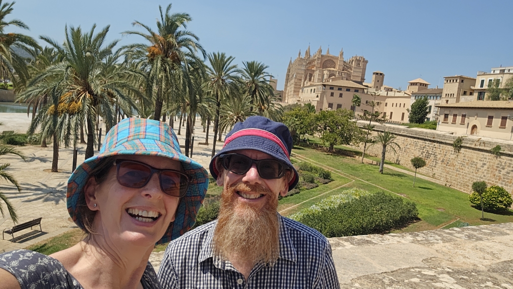 Julie and Jay with palm trees and Palma cathedral in the background